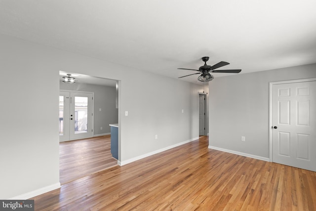 unfurnished room with ceiling fan, baseboards, and light wood-style floors