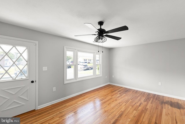 foyer featuring baseboards, a ceiling fan, and wood finished floors