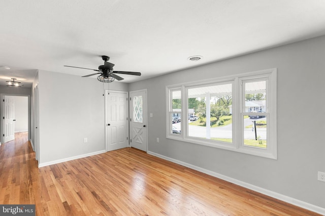 interior space featuring visible vents, baseboards, ceiling fan, and light wood-style floors