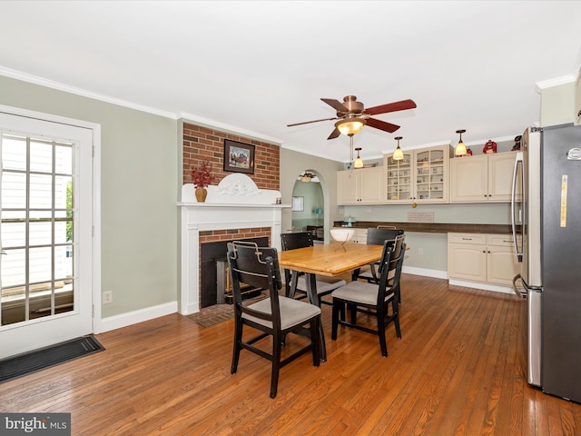 7214 Honeybush Dr, Mount Airy, MD 21771 - dining area with a fireplace, hardwood / wood-style flooring, crown molding, ceiling fan, and baseboards