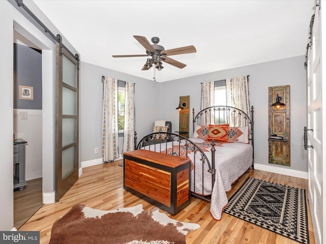 7214 Honeybush Dr, Mount Airy, MD 21771 - bedroom featuring a barn door, wood finished floors, baseboards, and ceiling fan