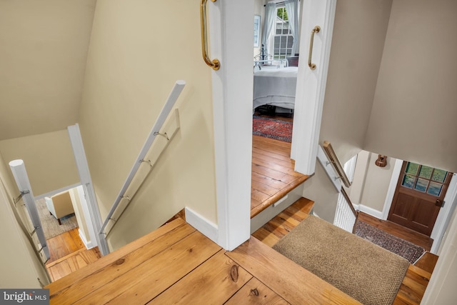 staircase featuring baseboards and wood finished floors