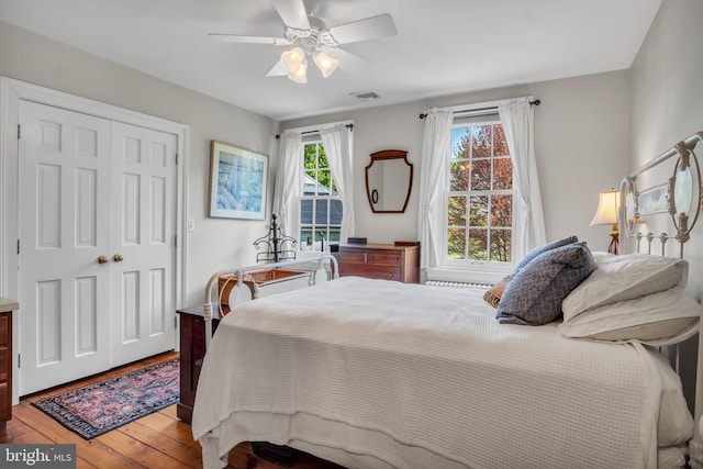 bedroom featuring visible vents, a closet, hardwood / wood-style floors, and ceiling fan