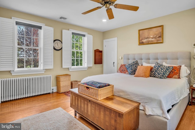 bedroom featuring visible vents, radiator, wood finished floors, ceiling fan, and recessed lighting