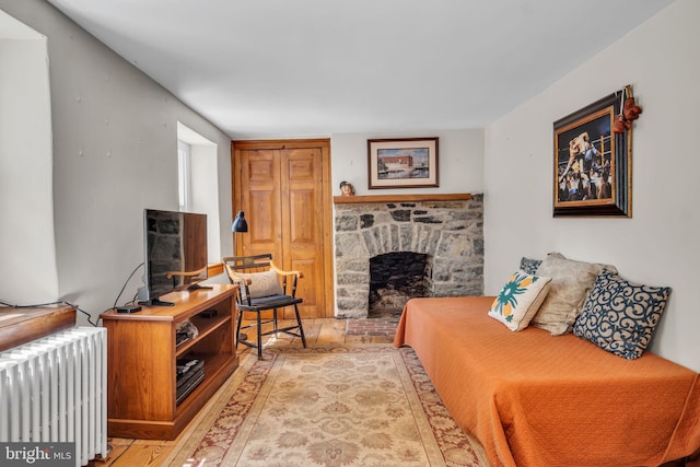 living area featuring radiator heating unit and a fireplace