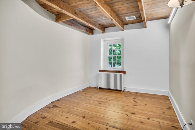 spare room featuring visible vents, wood ceiling, radiator heating unit, and hardwood / wood-style floors