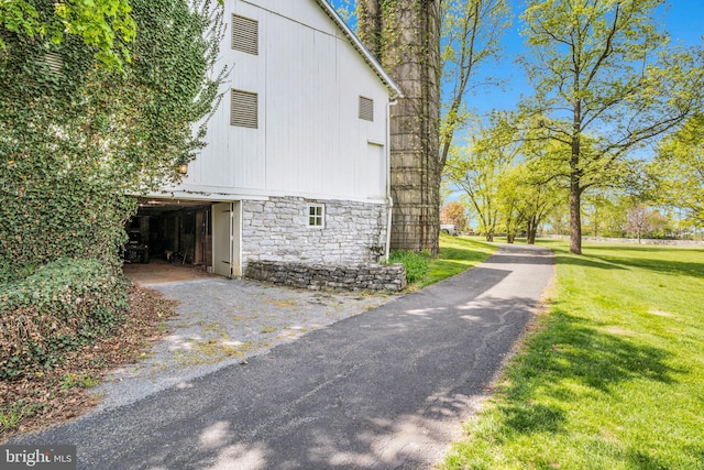 view of side of property featuring a lawn and stone siding