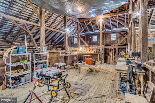 miscellaneous room featuring a workshop area, lofted ceiling, and hardwood / wood-style flooring