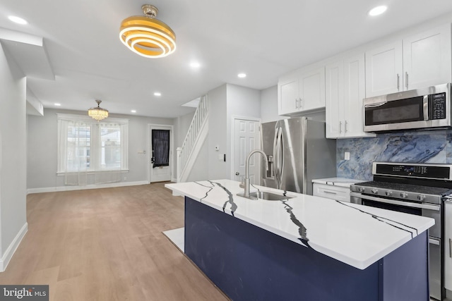 6227 Delancey St, Philadelphia, PA 19143 - kitchen featuring white cabinetry, a sink, baseboards, stainless steel appliances, and light wood-style flooring