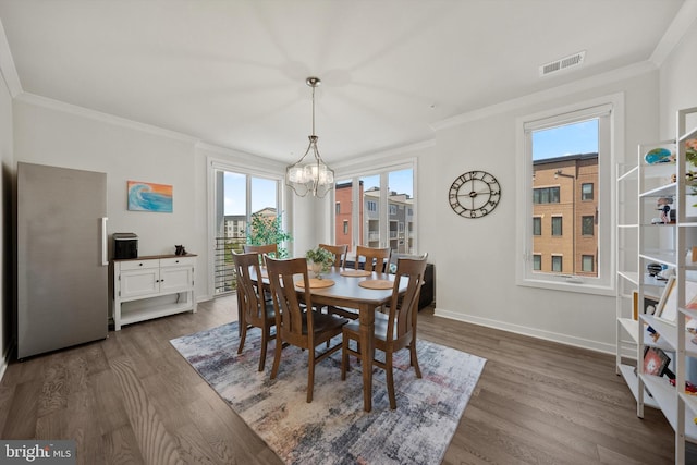 dining room with a chandelier, visible vents, ornamental molding, and a healthy amount of sunlight