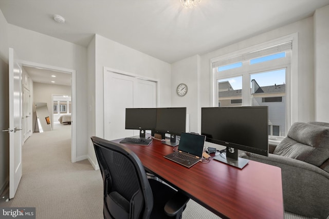 office area featuring baseboards and light colored carpet