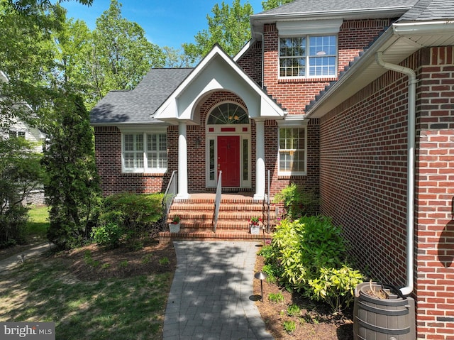 view of front of property featuring brick siding and a shingled roof