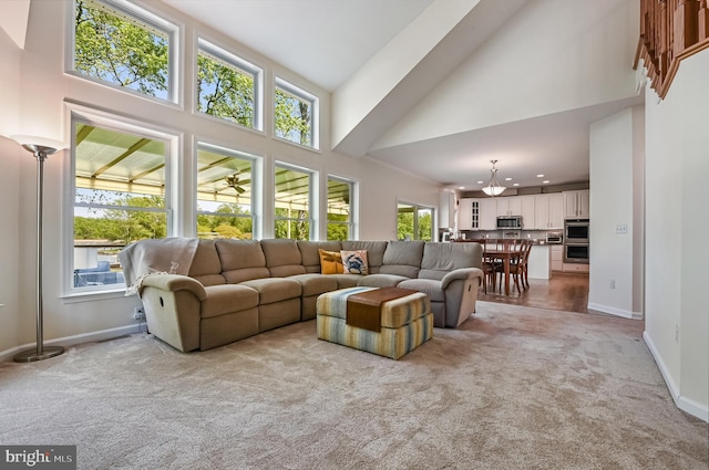 living room with light colored carpet, recessed lighting, baseboards, and a high ceiling