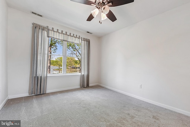unfurnished room with carpet floors, a ceiling fan, baseboards, and visible vents