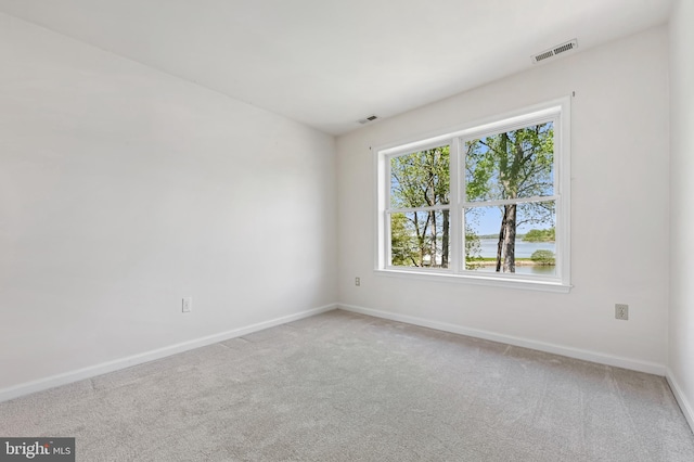 spare room featuring baseboards, carpet, and visible vents