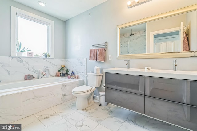 full bathroom featuring toilet, a sink, marble finish floor, and a garden tub