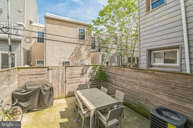 view of patio / terrace with central air condition unit, fence, area for grilling, and outdoor dining space