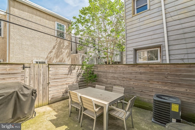 view of patio with a fenced backyard, central air condition unit, area for grilling, and outdoor dining space