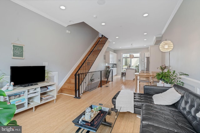 living area featuring light wood-type flooring, ornamental molding, and recessed lighting