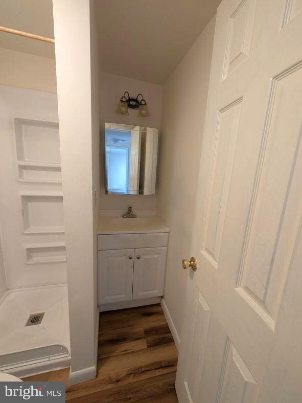 405 Poplar St, Salisbury, MD 21804 - bathroom with baseboards, walk in shower, vanity, and wood finished floors