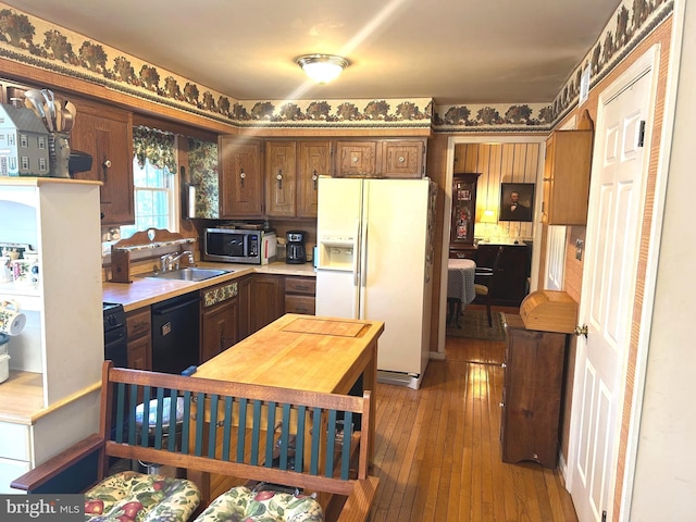 6908 Baltimore Ave, Hyattsville, MD 20782 - kitchen with white refrigerator with ice dispenser, stainless steel microwave, dishwasher, a sink, and light countertops