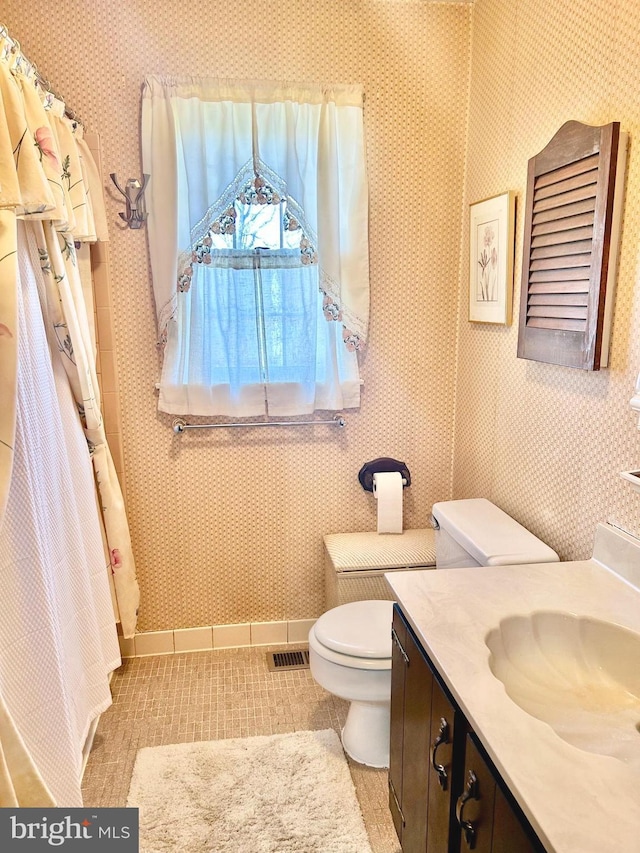 6908 Baltimore Ave, Hyattsville, MD 20782 - full bath featuring toilet, vanity, tile patterned floors, baseboards, and wallpapered walls