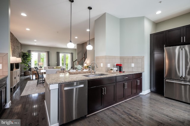 kitchen with a sink, dark wood-style flooring, open floor plan, and stainless steel appliances