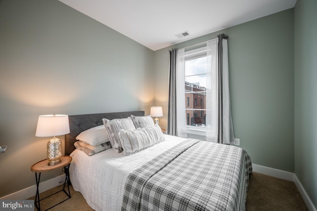 carpeted bedroom with visible vents and baseboards