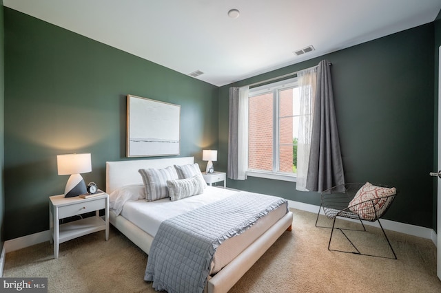 bedroom with baseboards, visible vents, and carpet