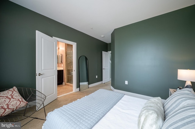 bedroom featuring connected bathroom, baseboards, and light carpet