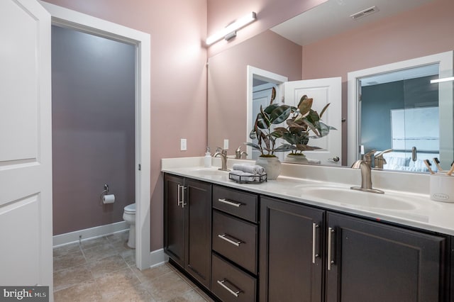 2006 Potomac Ave, Alexandria, VA 22301 - bathroom featuring toilet, double vanity, and baseboards
