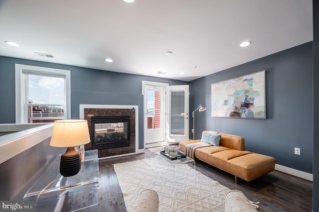 living room with a healthy amount of sunlight, baseboards, wood finished floors, and visible vents