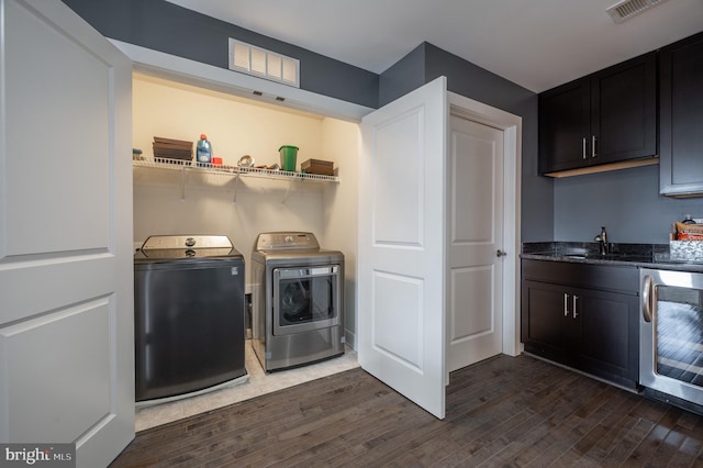 clothes washing area featuring separate washer and dryer, laundry area, dark wood-style floors, and visible vents