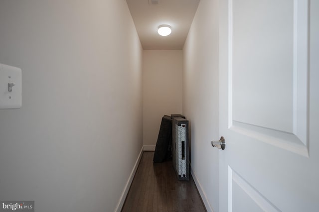 hallway featuring baseboards and dark wood finished floors