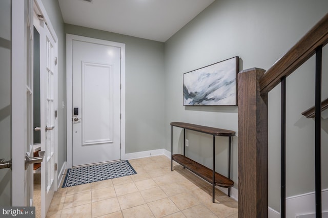 entryway with baseboards and light tile patterned floors