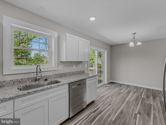 kitchen with stainless steel dishwasher, white cabinetry, an inviting chandelier, and a sink