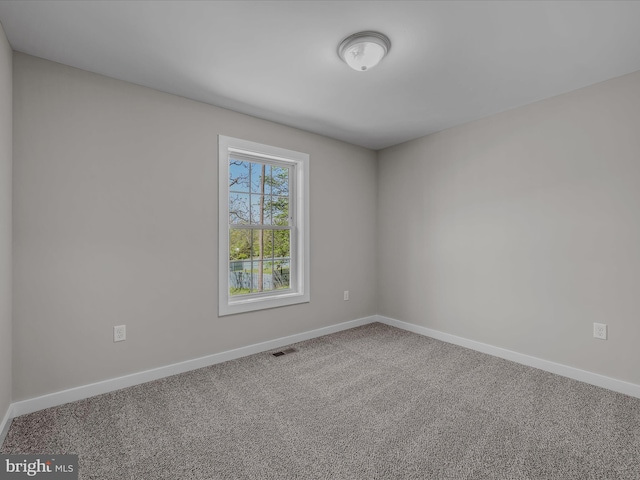 unfurnished room with baseboards, carpet, and visible vents