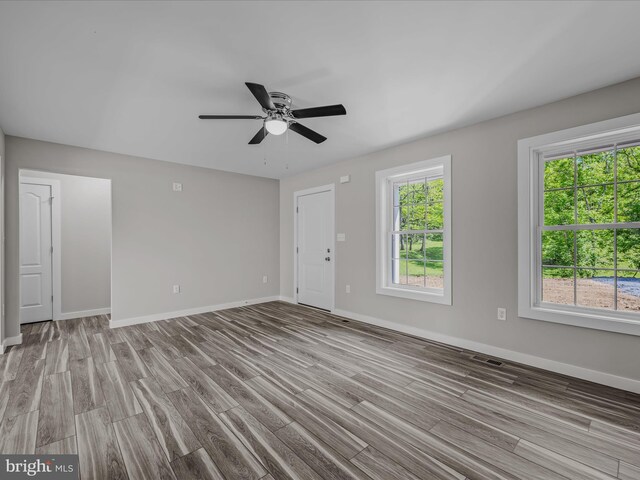 unfurnished living room featuring baseboards, ceiling fan, wood finished floors, and visible vents