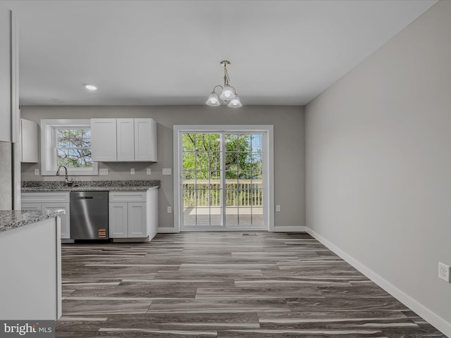 kitchen with dark wood-style flooring, light stone countertops, a chandelier, baseboards, and stainless steel dishwasher
