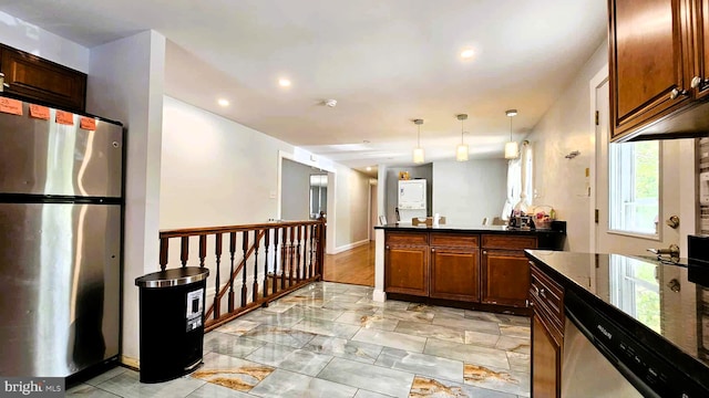 kitchen featuring decorative light fixtures, dark countertops, a peninsula, marble finish floor, and stainless steel appliances