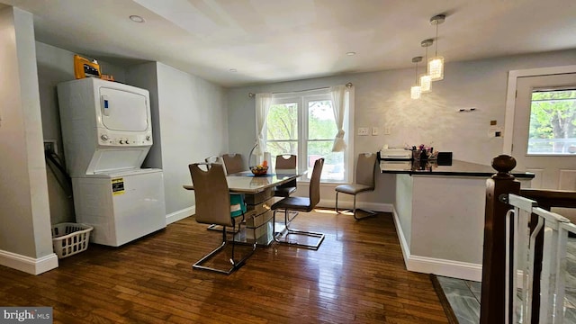 dining space with hardwood / wood-style flooring, baseboards, and stacked washer and clothes dryer