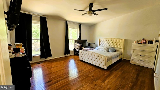bedroom featuring baseboards, multiple windows, visible vents, and dark wood-type flooring