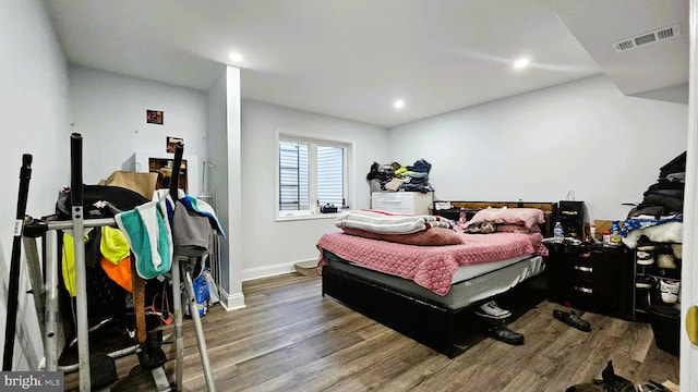 bedroom featuring baseboards, recessed lighting, wood finished floors, and visible vents