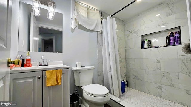 bathroom featuring vanity, toilet, and tiled shower