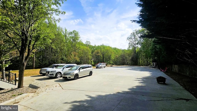 view of car parking with a wooded view