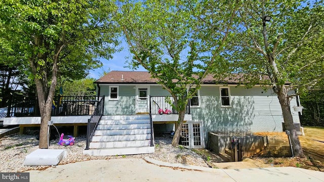 rear view of house with stairway, french doors, and a wooden deck