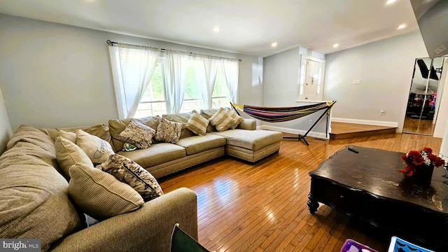 living room with wood-type flooring, recessed lighting, and baseboards
