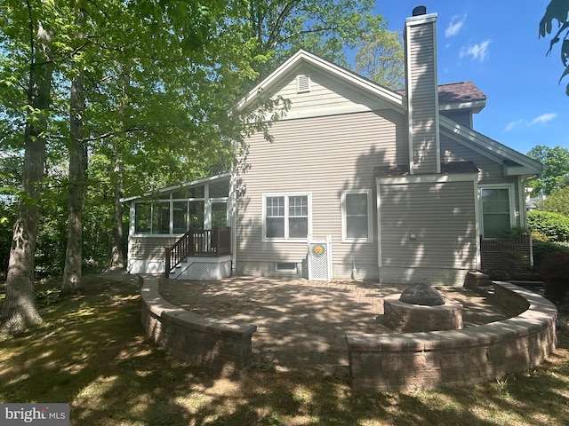 11801 Pond Crest Ct, New Market, MD 21774 - back of property with a fire pit, a sunroom, a chimney, and a patio