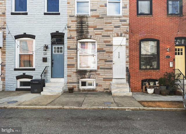 view of property with stone siding and entry steps