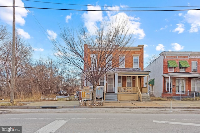 view of front of home with covered porch and brick siding